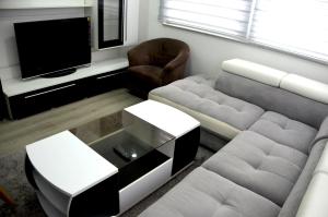 a living room with a couch and a tv at Apartman Alić in Vogošća