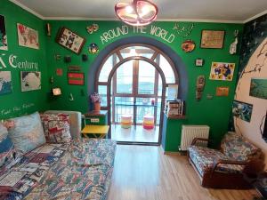 a living room with a bed and a green wall at Hostel Amazing Ionika CenterCity in Chişinău