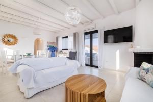 a living room with a white couch and a table at Princess Villas Oasis Mykonos in Kalafatis