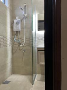 a shower with a glass door in a bathroom at Summerland Seaside Villa in Kampong Telaga Papan