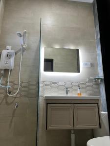 a bathroom with a shower and a sink and a mirror at Summerland Seaside Villa in Kampong Telaga Papan