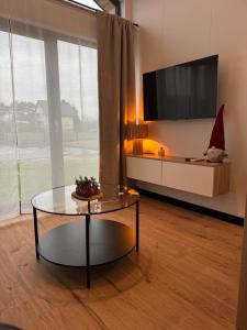 a living room with a table and a tv at Pniówek Chill in Zamość