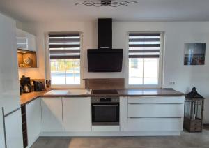 a kitchen with white cabinets and a stove top oven at Haus Möwenkind in Zirchow