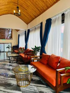 a living room with orange furniture and blue curtains at Las Vegas Garden Hotel-Kampala in Kampala