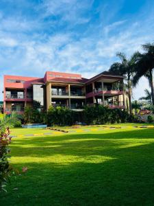 a large building with a lawn in front of it at Las Vegas Garden Hotel-Kampala in Kampala