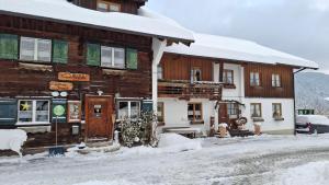 a wooden building in the snow with snow covered at Landhaus Schmid in Oberstdorf