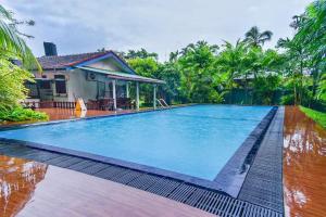 a swimming pool in front of a house at Green Villa in Kahawa