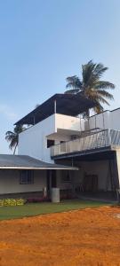 a white house with a palm tree in front of it at Flying Fox in Bangalore