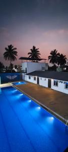 a swimming pool with blue lights in front of a building at Flying Fox in Bangalore
