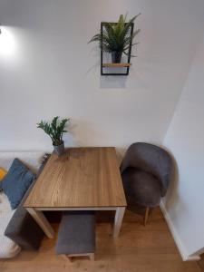 a living room with a wooden table and a chair at Apartament Na Rynku in Bytom
