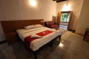 a bedroom with a bed with a red towel on it at Vayuvana Heritage Organic Farm Resort in Panamaram +95 photos