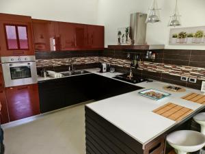 a kitchen with brown cabinets and a white counter top at ''A casa di Lele'' in Avola