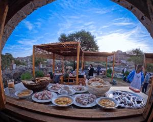 a table filled with plates of food on a table at ASSINGAR Island in Aswan