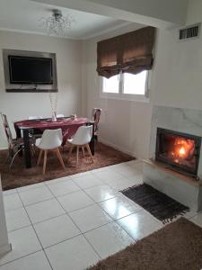 ein Wohnzimmer mit einem Tisch und einem Kamin in der Unterkunft Maisonette Stella in Kardítsa