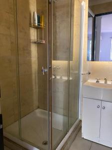 a shower with a glass door next to a sink at Piso Céntrico Maipú in Maipú