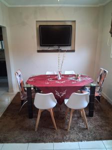 ein Esszimmer mit einem roten Tisch und Stühlen in der Unterkunft Maisonette Stella in Kardítsa
