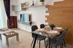 a dining room with a table and chairs and a television at Pablo House Beach in Telde