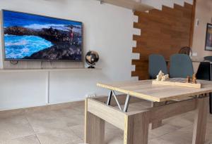 a living room with a table and a tv on a wall at Pablo House Beach in Telde