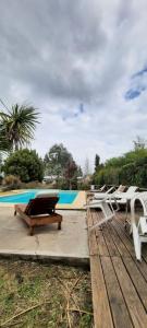 a group of lounge chairs sitting next to a pool at Casas de Campo Hoja in Chascomús +16 photos