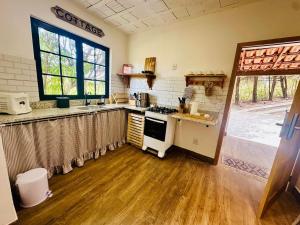 a kitchen with a sink and a stove top oven at Casinha da Serra in Rio Acima +12 photos