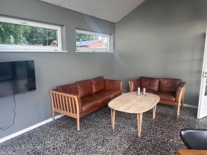 a living room with a couch and a table at Herning, Sunds Lake Beautiful View & Spa 105 m2 in Sunds