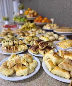 a table topped with plates of pastries and other foods at Hotel Comodoro in Vilhena