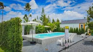 a swimming pool with chairs and an umbrella at บลูคริสตัลรีสอร์ทแหลมสิงห์ in Laem Sing