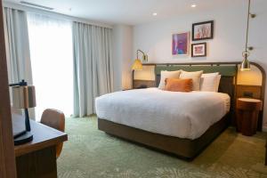 a bedroom with a large bed and a television at Four Points by Sheraton Georgetown in Georgetown