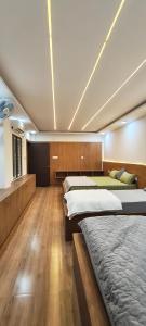 two beds in a large room with wooden floors at Flying Fox in Bangalore