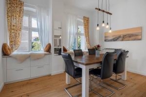a dining room with a wooden table and black chairs at Boardinghouse am Herforder Tor für 8 Personen auf 185 m2 in Bad Salzuflen