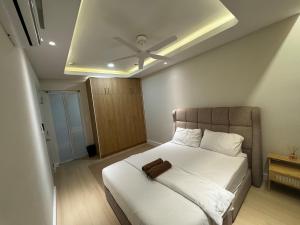 a bedroom with a white bed with a ceiling fan at InapByDaddy's Near KLIA SIC Sepang 4BR Fully Aircond in Sepang +14 photos