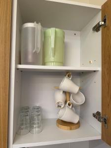 a white cupboard with dishes and glass jars at InapByDaddy's Near KLIA SIC Sepang 4BR Fully Aircond in Sepang