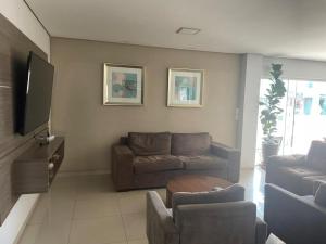 a living room with a couch and a tv at Hotel Comodoro in Vilhena