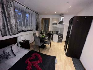 a bedroom with a bed and a table and a kitchen at Willa Seba in Zakopane