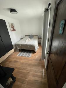 a bedroom with a bed and a wooden floor at Tayka Suite in La Serena