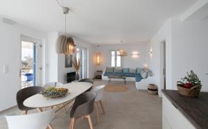 a dining room and living room with a table and chairs at Villa Salt in Naxos Chora