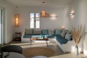 a living room with a blue couch and a table at Villa Salt in Naxos Chora