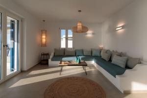 a living room with a blue couch and a table at Villa Salt in Naxos Chora
