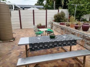 a patio with a table and chairs and plants at Mimosa House Twin Room in Brackenfell