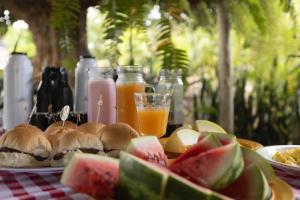 a table with sandwiches and fruit on a table with drinks at Restaurante e Pousada Mandacaru Abacate in Campestre