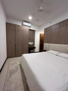 a bedroom with a large white bed and wooden cabinets at TriZen Luxe Apartments in Colombo +24 photos