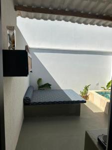 a bed in the corner of a room next to a pool at BaleiaLofts Kite Village in Itapipoca