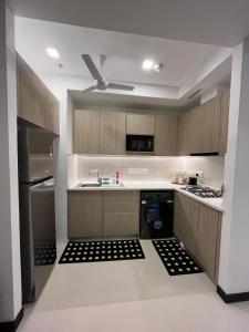 a kitchen with wooden cabinets and a stove top oven at TriZen Luxe Apartments in Colombo