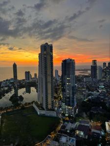 a city skyline with skyscrapers and the ocean at sunset at TriZen Luxe Apartments in Colombo