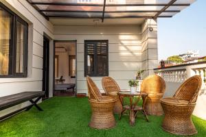 a patio with wicker chairs and a table and a bench at The Hush Nepal in Kathmandu