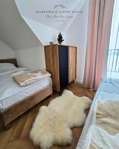 a bedroom with two beds and a rug on the floor at Markowicz Alpine House in Szaflary