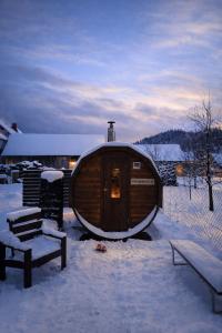 a large wooden building in the snow with a bench at Vila Hafira in Zuberec