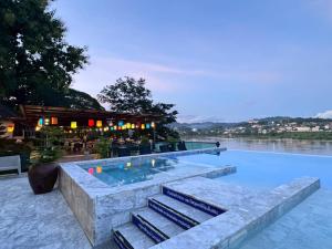 a swimming pool with stairs leading up to a building at Chiangkhong Teak Garden Riverfront Hotel in Chiang Khong