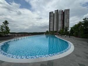 a large swimming pool with two tall buildings in the background at InapByDaddy's Near KLIA SIC Sepang 4BR Fully Aircond in Sepang