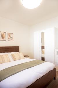 a bedroom with a large bed and a light fixture at Tailor Garden House in Tríkala